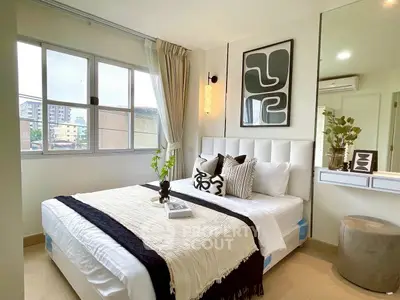 Modern bedroom with stylish decor and large window offering city views