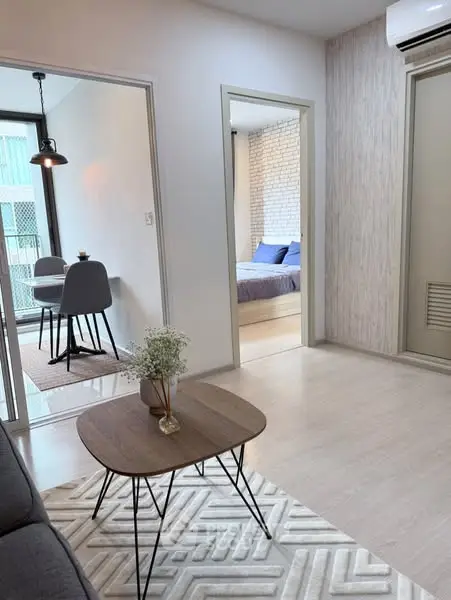 Modern living room with stylish decor and view into dining and bedroom areas