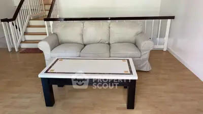 Spacious living room with cozy sofa and elegant coffee table on wooden flooring.