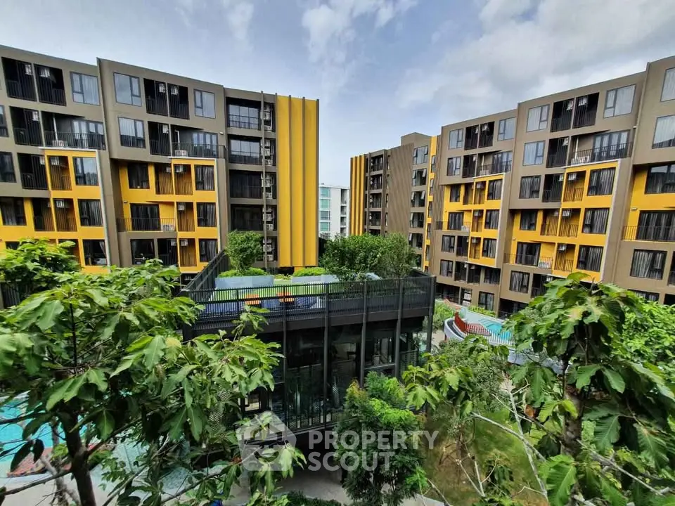 Modern apartment complex with vibrant yellow accents and lush greenery