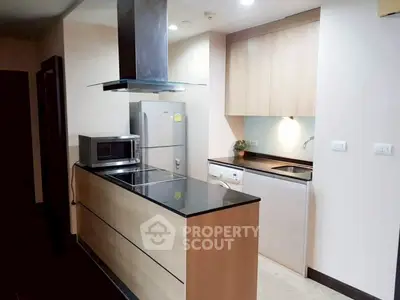 Modern kitchen with sleek appliances and wooden cabinetry in a stylish apartment.