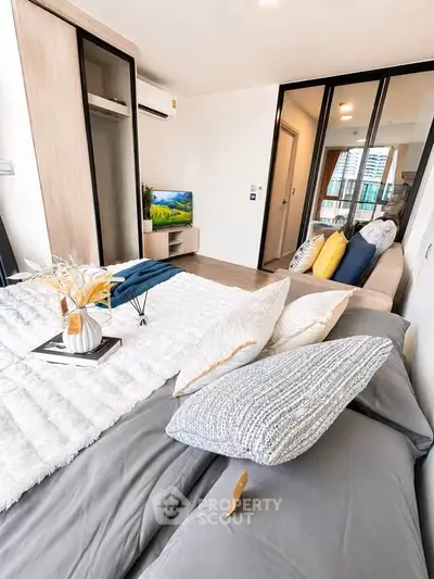 Modern bedroom with stylish decor and large windows offering natural light.
