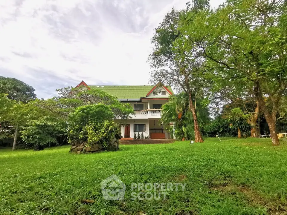 Charming countryside house with lush green garden and spacious lawn, perfect for serene living.