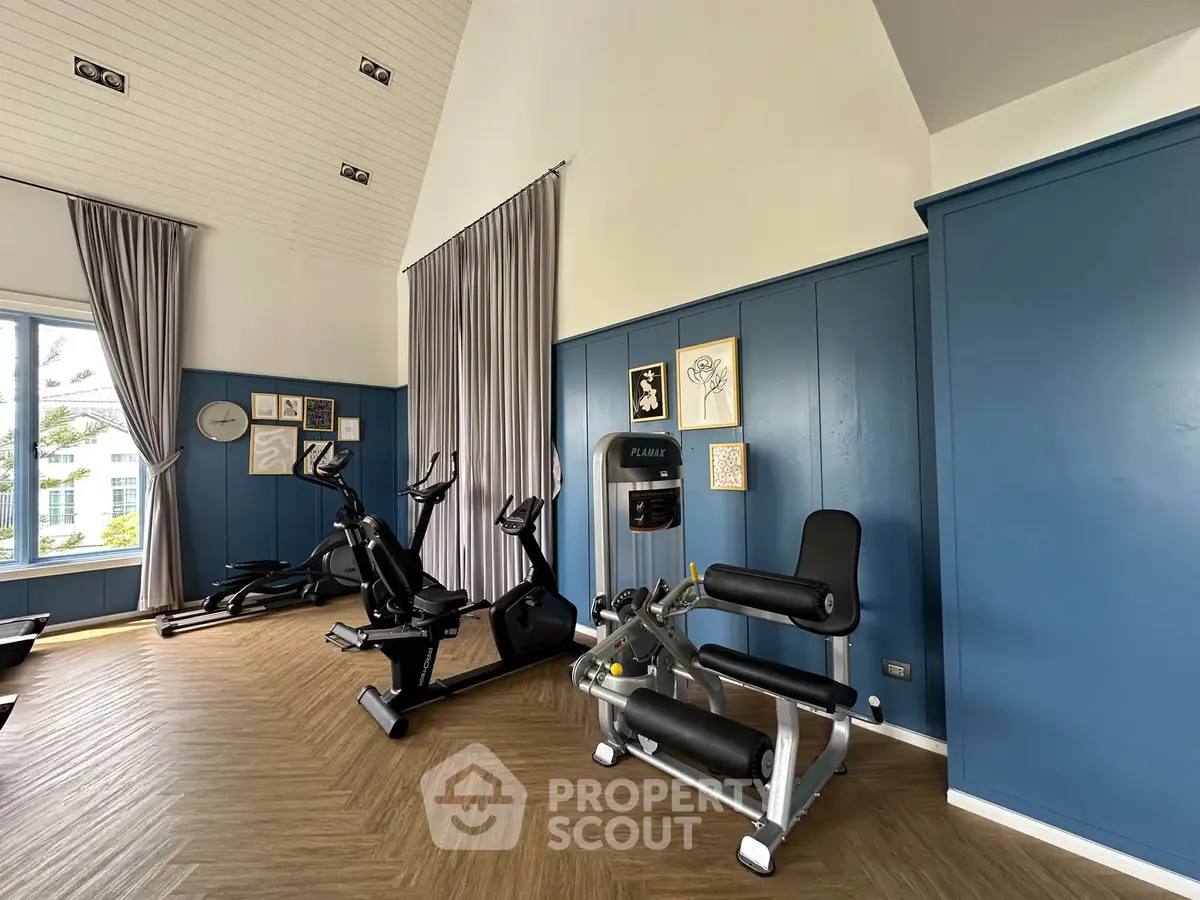 Modern gym with exercise equipment and stylish blue paneling, perfect for fitness enthusiasts.