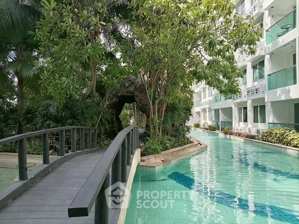 Luxurious apartment complex with serene pool and lush greenery, perfect for relaxation and modern living.