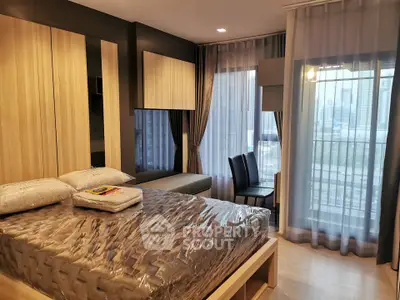 Modern bedroom with city view, featuring stylish decor and floor-to-ceiling windows for natural light.