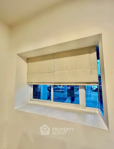 Cozy window nook with modern blinds offering a glimpse of the urban street view.