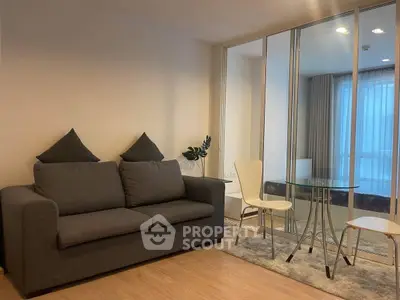 Modern living room with cozy sofa and glass dining table in stylish apartment.