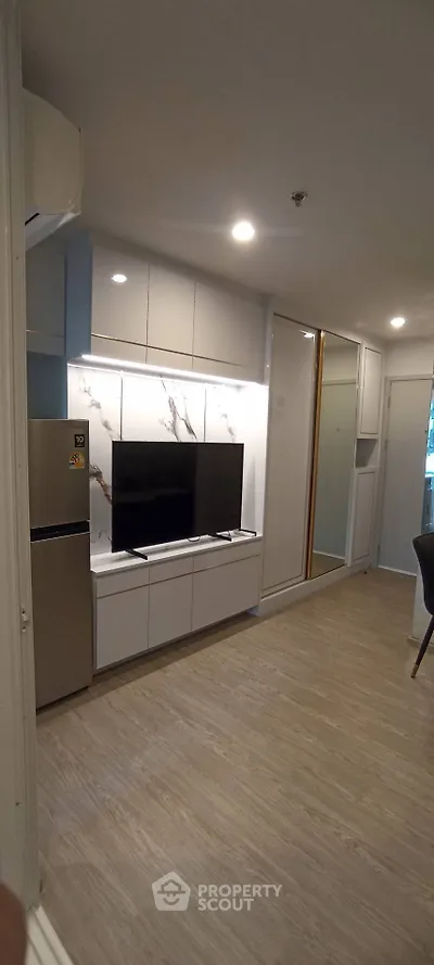 Modern living room with sleek design, featuring a wall-mounted TV and stylish cabinetry.