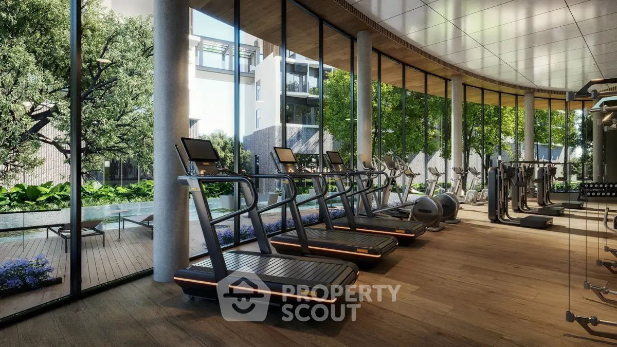 Luxurious gym with modern equipment and poolside view in upscale residential complex.