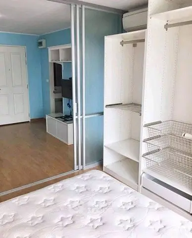 Modern bedroom with built-in closet and mirrored sliding doors in a stylish apartment.