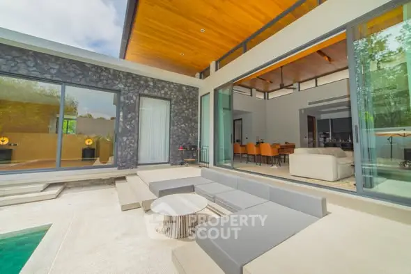 Luxurious modern home with spacious outdoor seating and pool area, perfect for entertaining.