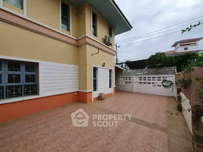 Spacious exterior view of a two-story home with tiled patio and secure fencing.