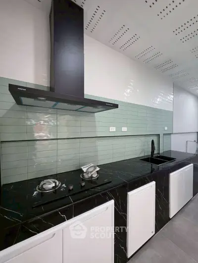 Modern kitchen with sleek black countertops and gas stove