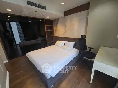 Modern bedroom with sleek design, featuring a comfortable bed, office chair, and desk in a stylish setting.