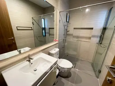 Modern bathroom with glass shower and sleek fixtures in a contemporary home.