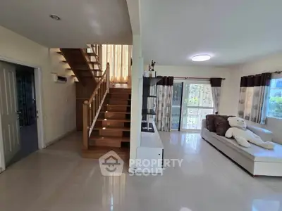 Spacious living room with modern staircase and cozy seating area