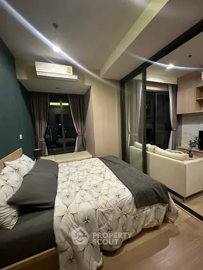 Modern bedroom with glass partition and cozy living area in stylish apartment