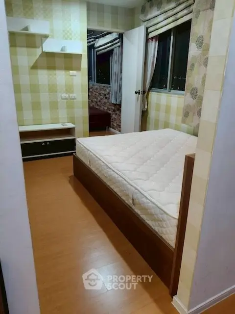 Cozy bedroom with wooden flooring and large windows offering a serene view.