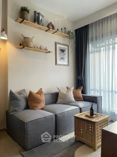 Stylish modern living room with cozy gray sofa, wooden shelves, and elegant decor.