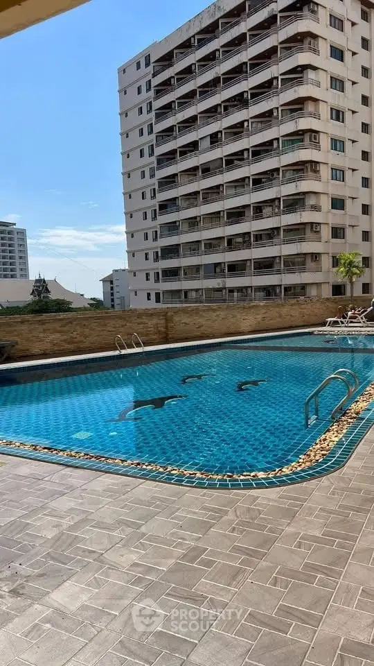 Luxurious apartment building with a stunning outdoor pool and city view.