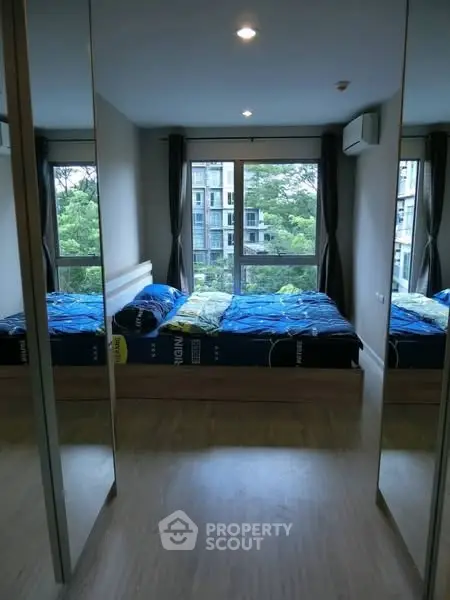 Modern bedroom with mirrored closets and scenic window view