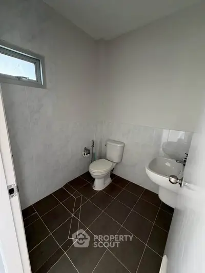 Modern minimalist bathroom with sleek tiles and compact design.