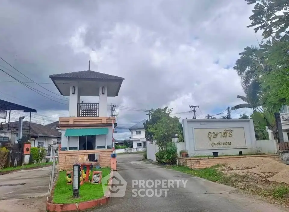 Charming gated community entrance with lush greenery and welcoming signage.