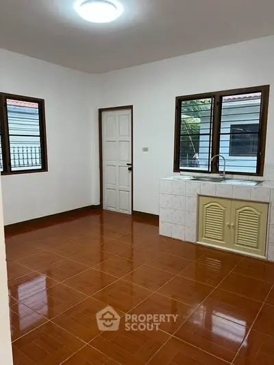 Spacious room with tiled floor and large windows, ideal for versatile use.