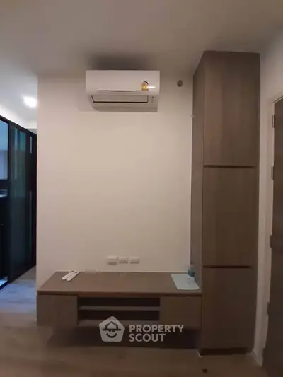 Modern minimalist interior with air conditioning and built-in storage in a sleek apartment unit.