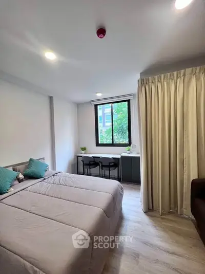 Modern bedroom with cozy decor and natural light from large window