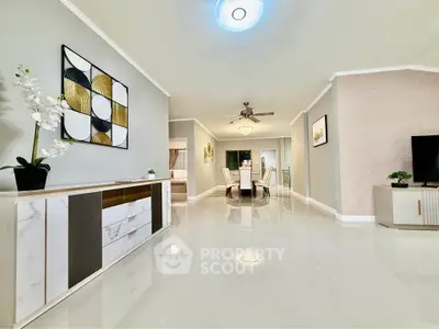 Spacious modern living room with elegant decor and dining area, featuring glossy floors and stylish furniture.
