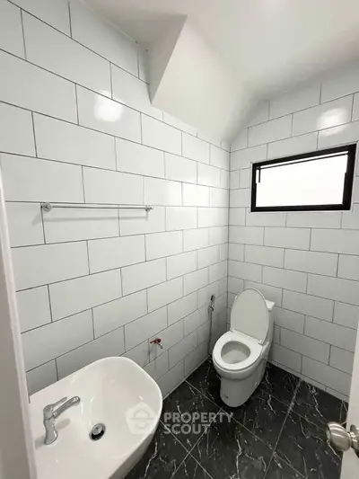 Modern bathroom with white tiled walls and sleek fixtures