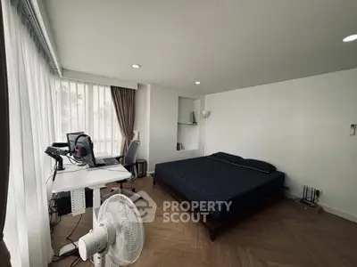 Modern bedroom with workspace, featuring sleek design and natural light, ideal for urban living.