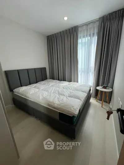 Modern bedroom with stylish bed and elegant curtains, perfect for a cozy retreat.