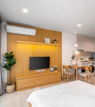 Modern studio apartment with stylish wooden decor and compact kitchen area.