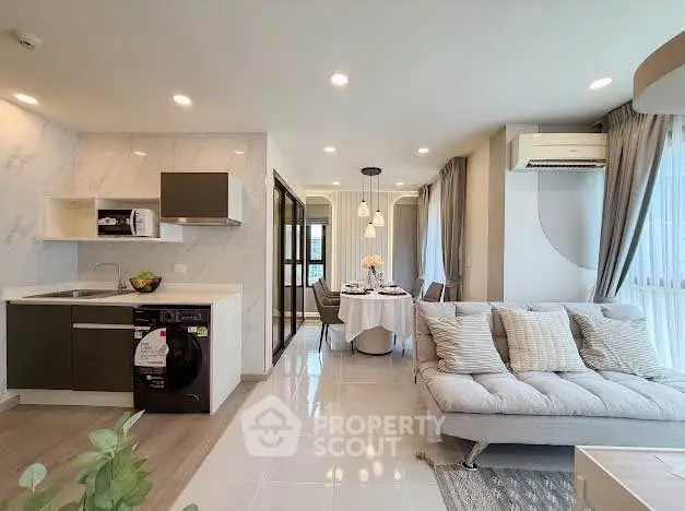 Modern open-plan living room and kitchen with stylish decor and natural light