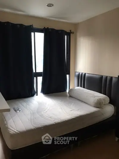 Cozy bedroom with large window and modern furnishings, perfect for relaxation and comfort.