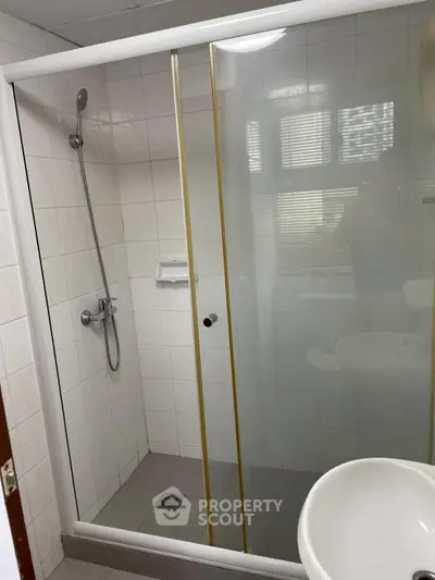 Modern bathroom with glass shower enclosure and sleek fixtures