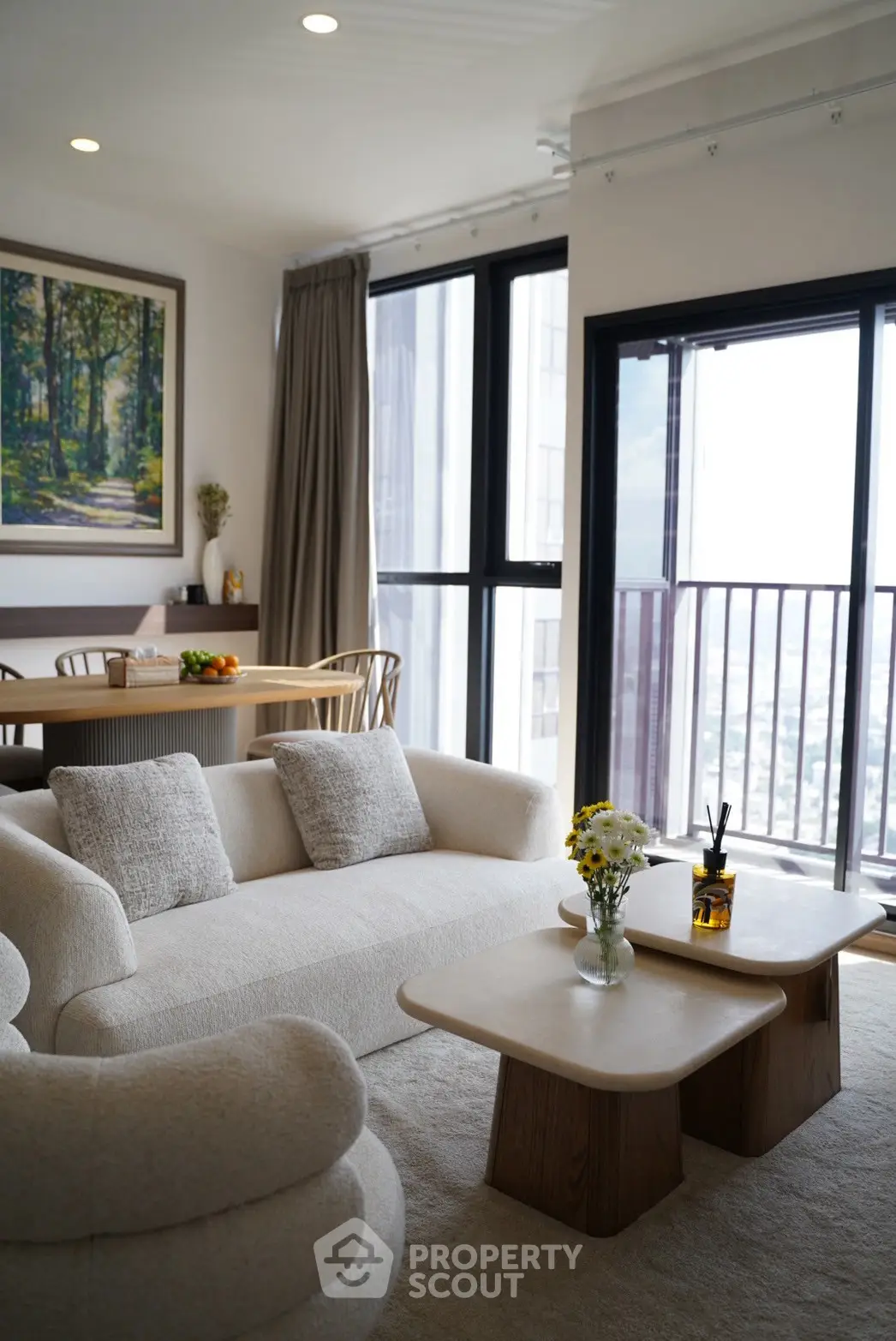 Elegant living room with cozy seating and large windows offering stunning city views.