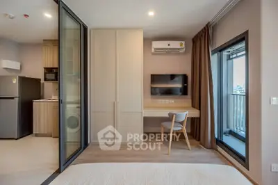 Modern studio apartment with kitchenette and balcony view, featuring sleek design and cozy ambiance.