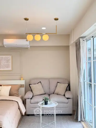 Modern bedroom with cozy sofa and stylish lighting in a bright apartment.