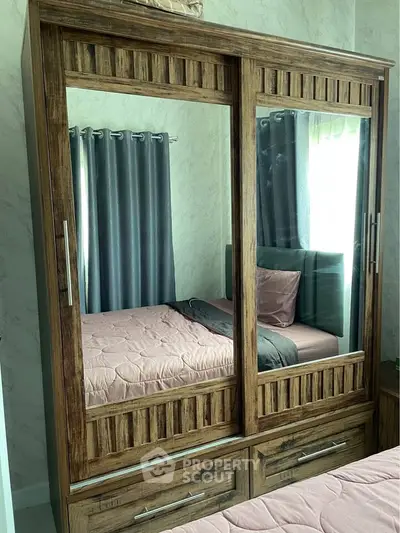 Cozy bedroom with wooden wardrobe and mirrored doors, featuring elegant curtains and a comfortable bed.
