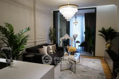 Luxurious living room with elegant decor and chandelier, featuring a cozy seating area and stylish furnishings.