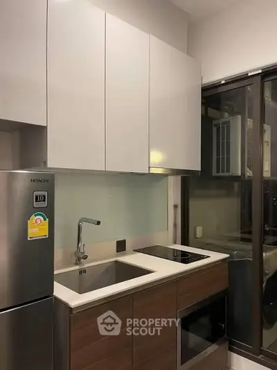 Modern kitchen with sleek cabinetry and built-in appliances in a compact layout.