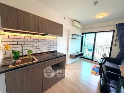 Modern kitchen and living area with city view, featuring sleek cabinetry and stylish decor.