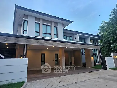 Modern two-story house with spacious driveway and sleek architectural design.