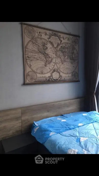 Cozy bedroom with vintage world map decor and blue cloud-themed bedding.