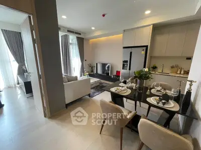 Modern open-plan living room and kitchen with elegant dining area and natural light.