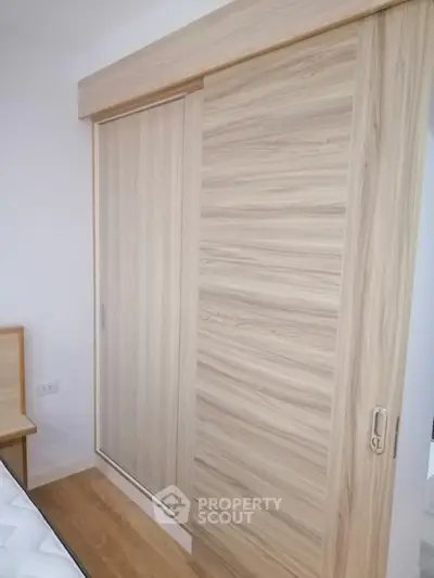 Modern bedroom with stylish wooden sliding closet doors